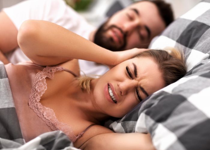 couple ronflement Homme qui ronfle, femme qui se bouche les oreilles